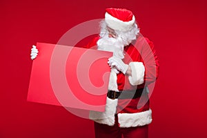 Santa Claus pointing in blank advertisement banner isolated on red background with copy space red leaf