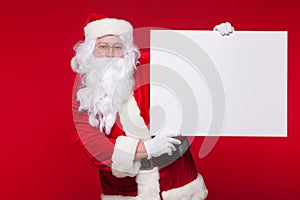 Santa Claus pointing in blank advertisement banner isolated on red background with copy space