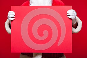 Santa Claus pointing in blank advertisement banner on red background with copy space red leaf