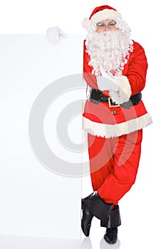 Santa Claus pointing on blank white wall, advertisement banner with copy space. Isolated on white background. Full