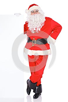 Santa Claus pointing on blank white wall, advertisement banner with copy space. Isolated on white background. Full