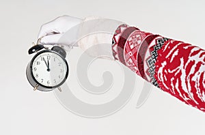 Santa Claus points to the clock before Christmas. Santa hat on the clock