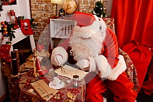 Santa Claus preparing for travel and looking at the world map