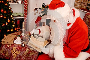 Santa Claus preparing for travel and looking at the world map