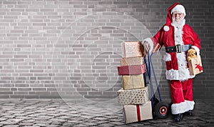 Santa Claus with presents stacked on a delivery trolley in a industrial warehouse theme and background