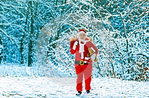 Santa Claus pulling huge bag of gifts on white nature background. Delivery christmas gifts. Winter Christmas greeting