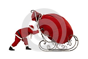 Santa Claus pushing sleigh with huge bag on it