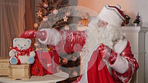 Santa Claus putting gifts in bag isolated near the