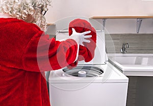Santa Claus putting his clothes in the washing machine photo