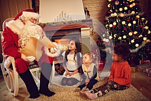Santa Claus read children`s whishes from long paper