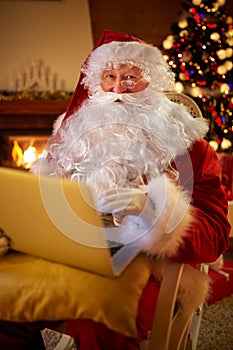 Santa Claus reading email on laptop requesting wish present list