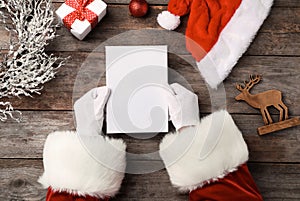 Santa Claus reading letter from child at table