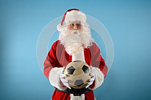 Santa claus ready to the soccer match with soccerball in hand