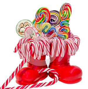 Santa Claus red boots, shoes with colored sweet lollipops, candys. Saint Nicholas boot with presents gifts.