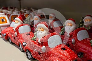 Santa Claus on a red car, a set of festive toys in the store.