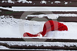 Santa Claus red hat on bench with snow