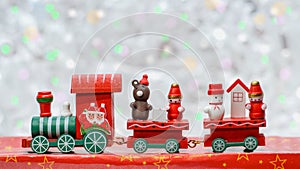 Santa Claus red wooden toy train with two carriages, bear, snowman and gnome. Christmas greeting card