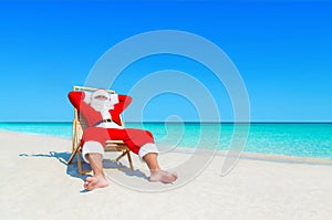 Santa Claus relax in sunlounger at sandy tropical sea beach