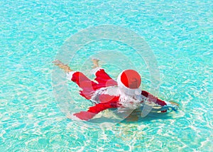 Santa Claus relax swimming in ocean water, Christmas traveling c