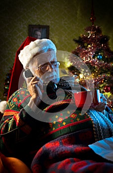 Santa Claus relaxing at home on the phone