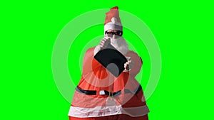 Santa Claus reveals a new cool tablet PC on a green background.