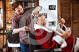 Santa claus shaving his personal barber