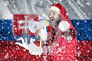 Santa Claus kričí do megafónu a ukazuje gesto ruky na pozadí vlajky Slovenska