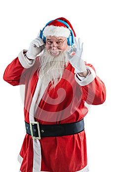 Santa claus showing hand okay sign while listening to music on headphones