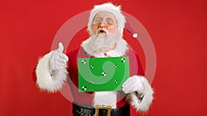 Santa Claus Shows an Approving Thumbs-up Gesture With Space for Text or Advertising on Red. Cheerful Santa Claus Holding