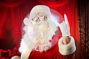 Santa Claus shows a hand a heavy rock symbol.