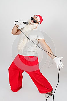 Santa Claus sings with a microphone in his hand. Isolated on white