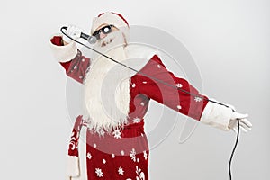 Santa Claus sings with a microphone in his hand. Isolated on white