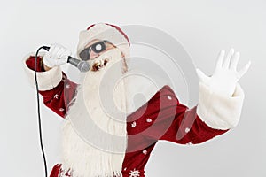 Santa Claus sings with a microphone in his hand. Isolated on white