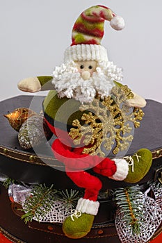 Santa Claus sits on vintage brouwn coffer with white christmas t