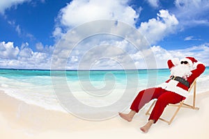Santa Claus sitting on beach chairs. Christmas holiday concept.
