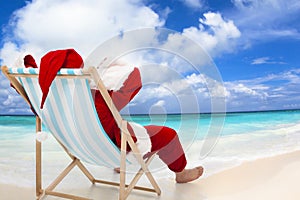 Santa Claus sitting on beach chairs. Christmas holiday concept. photo