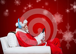 Santa claus sitting on chair and using mobile phone