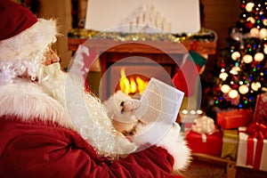 Santa Claus sitting and reading children wishes for x-mas