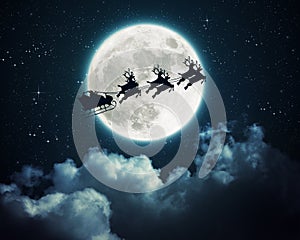 Santa Claus in a sleigh flying over the moon in the night