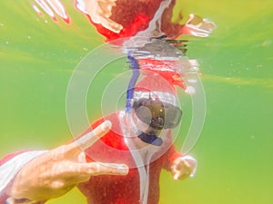 Santa claus is snorkeling underwater - christmas or happy new year concept. Christmas in the tropics after quarantine