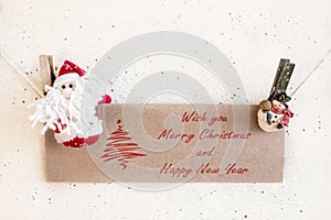 Santa Claus and snowman clothespin holding Christmas greeting ca