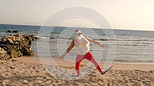 Santa Claus summer vacation. Father Christmas having fun. Funny Santa, in flippers runs through sandy beach to the sea