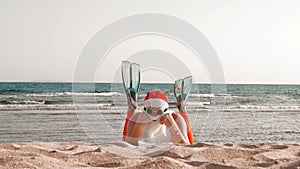 Santa Claus summer vacation. Santa Claus having fun. Funny Santa, in flippers, relaxing while lying on sandy beach by