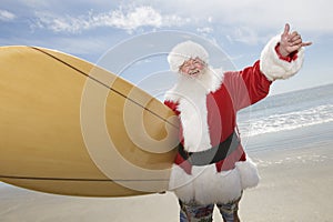 Santa Claus With Surf Board On Beach