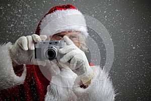 Santa Claus taking picture with old camera.