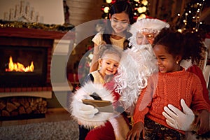 Santa Claus taking selfie during Christmas atmosphere with child