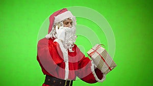 Santa Claus talking by phone and holding gift box. Christmas holiday concept. chromakey