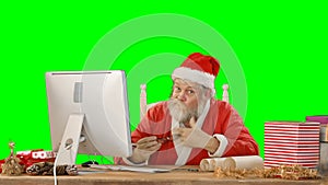 Santa claus talking while working on personal computer