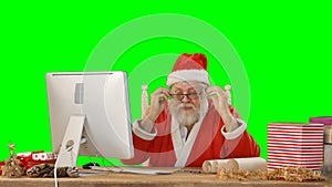 Santa claus talking while working on personal computer