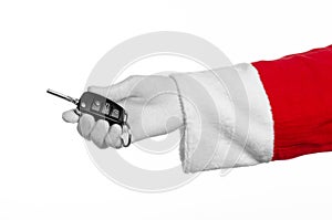 Santa Claus theme: Santa's hand holding the keys to a new car on a white background